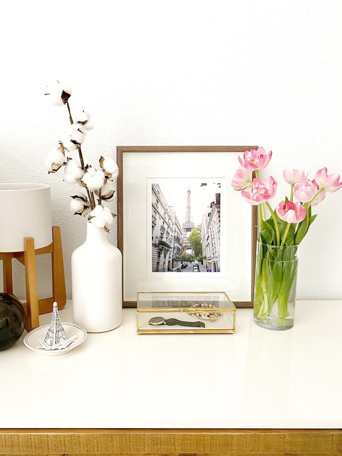 Image 1: Artifact Uprising Metal Tabletop Frame on a dresser next to vibrant flowers.