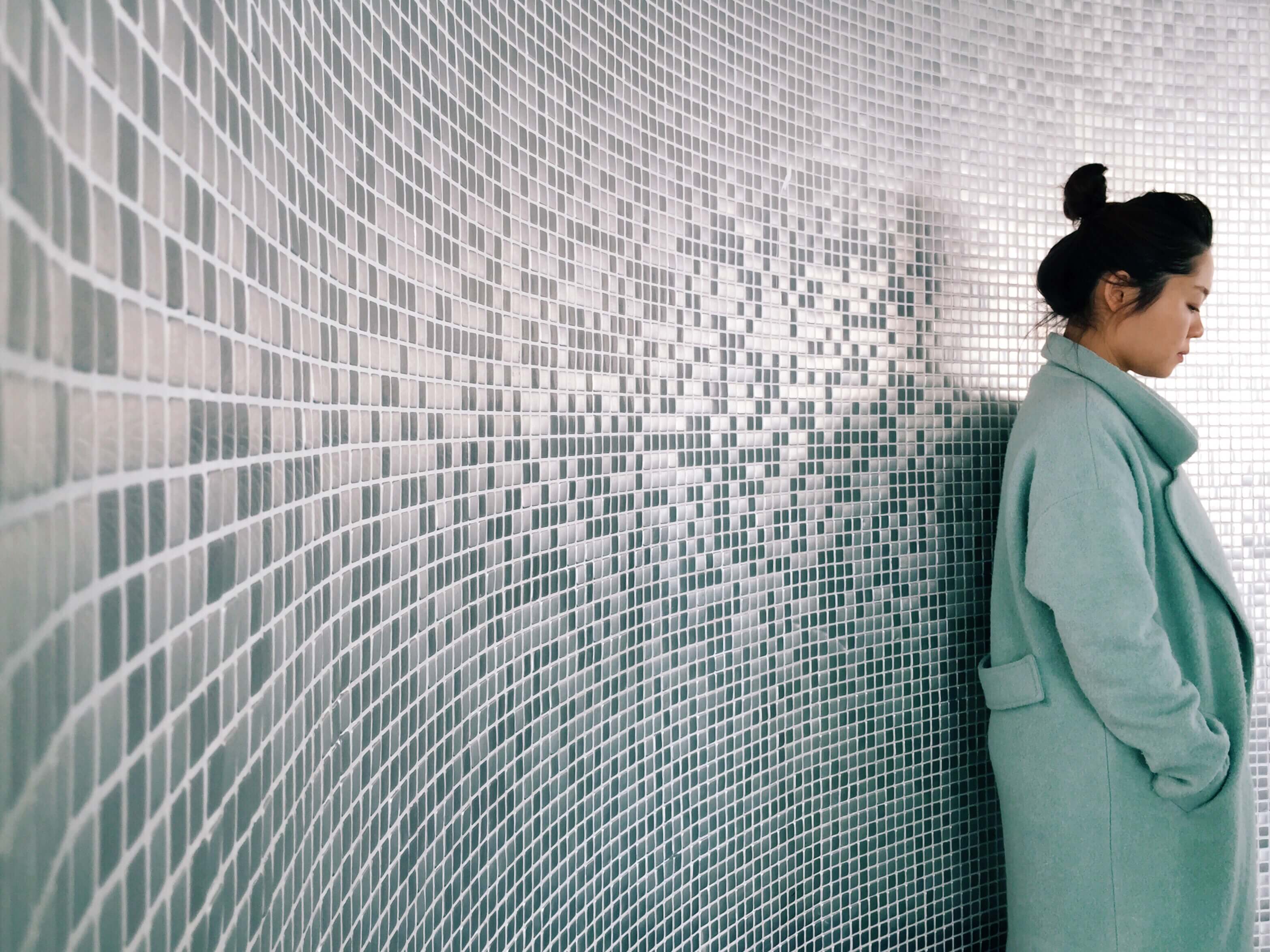 woman leaning against textured wall