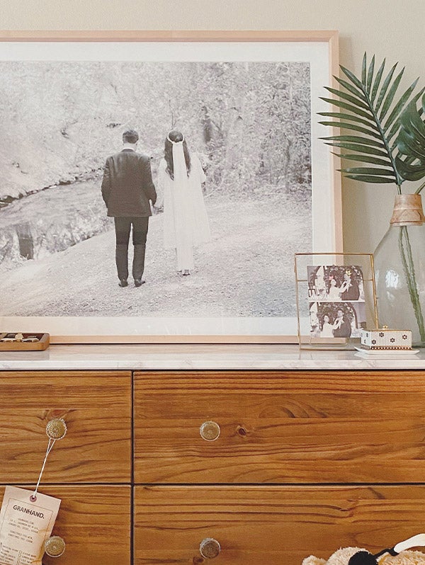 Large Artifact Uprising Gallery Frame with wedding photo atop mantle filled with plants and decor