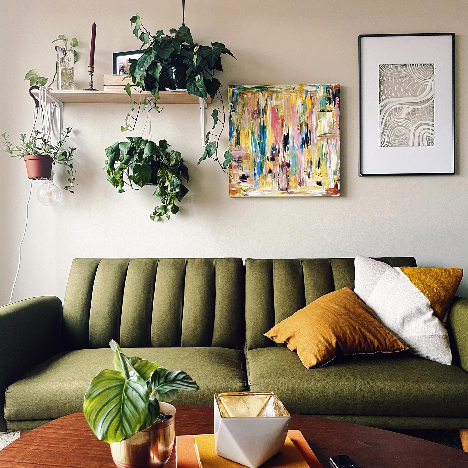 Stack of Artifact Uprising photo books on coffee table in front of mid-century modern olive green velvet couch