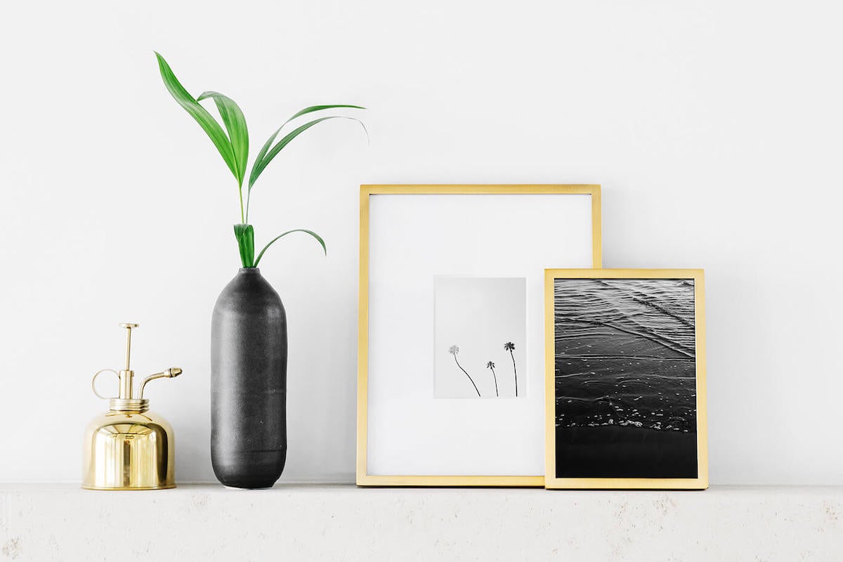 Mantle adorned with small tabletop frames and other decor