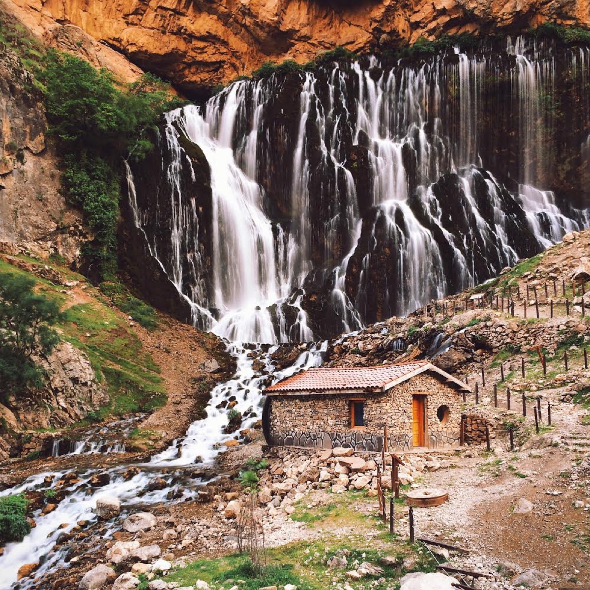 Dan Rubin photo of small hut in front of waterfall