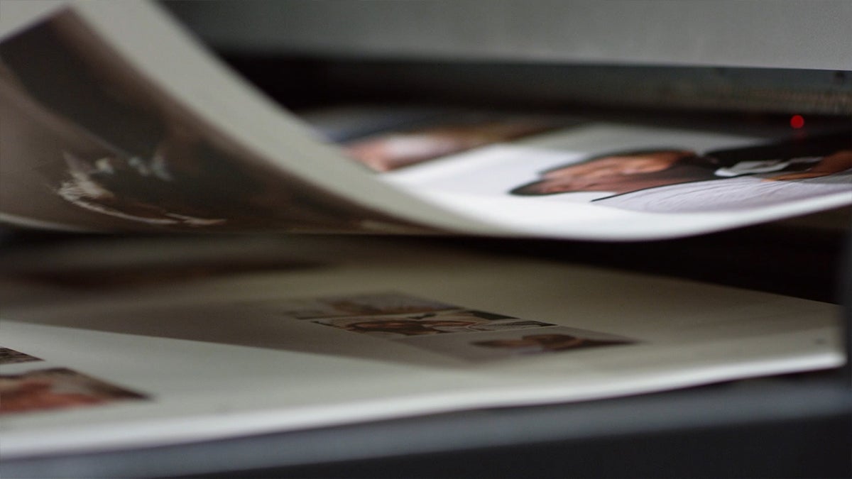 Pages of a photo book rolling off of the printer