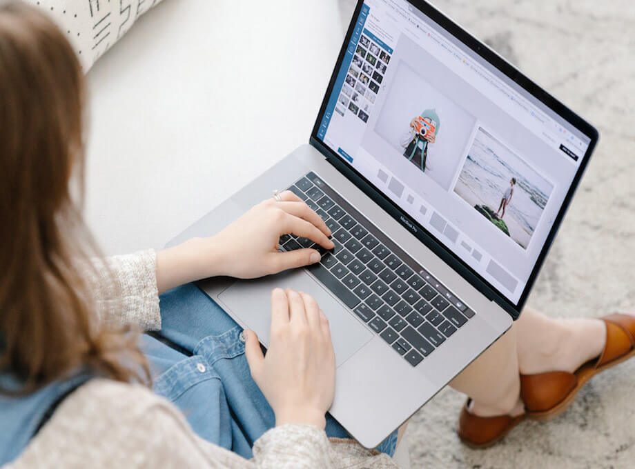 Overhead view of woman building photo book on her laptop