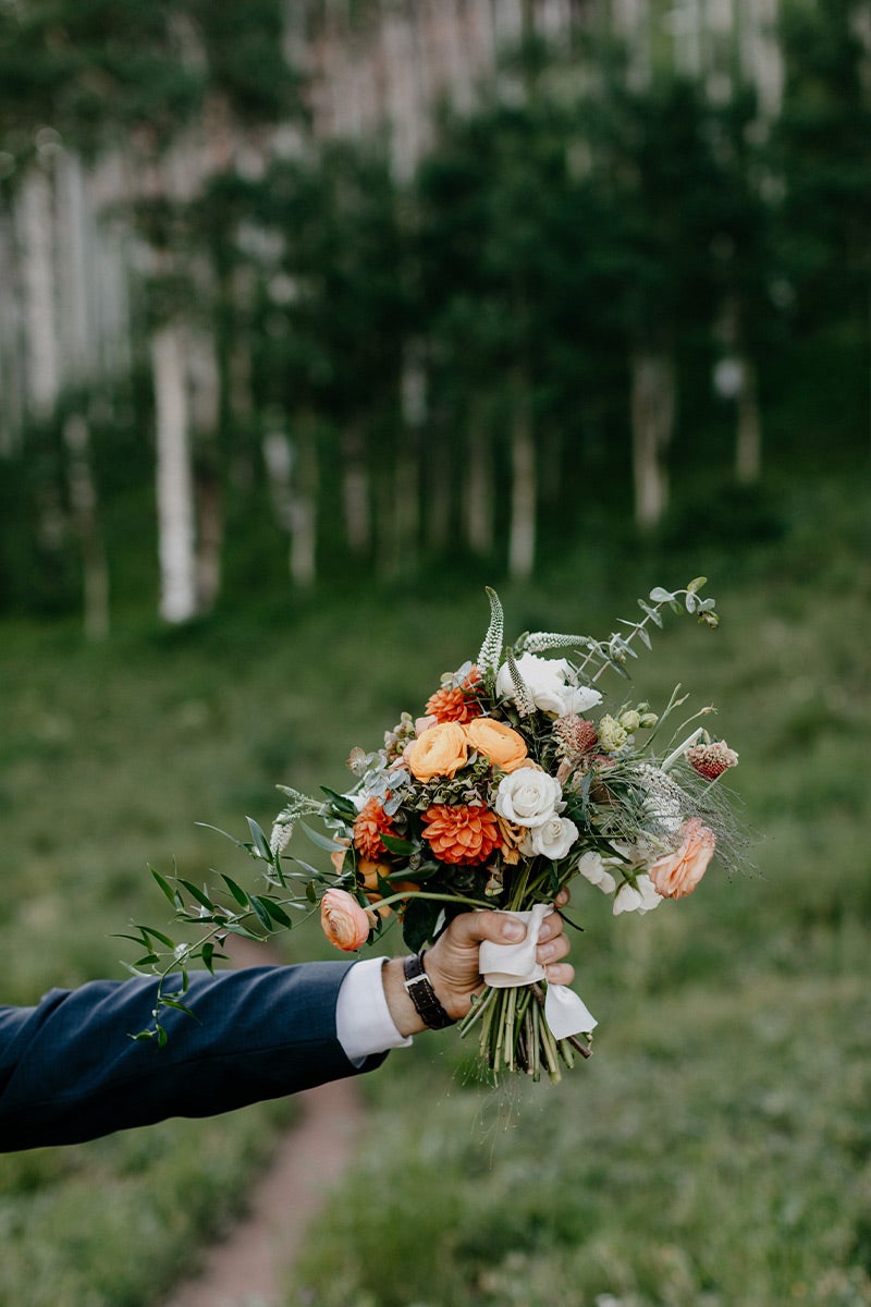 Hand holding up bridal bouquet