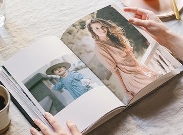 Artifact Uprising Hardcover Photo Book opened up to child photo on left page and graduation photo on right page