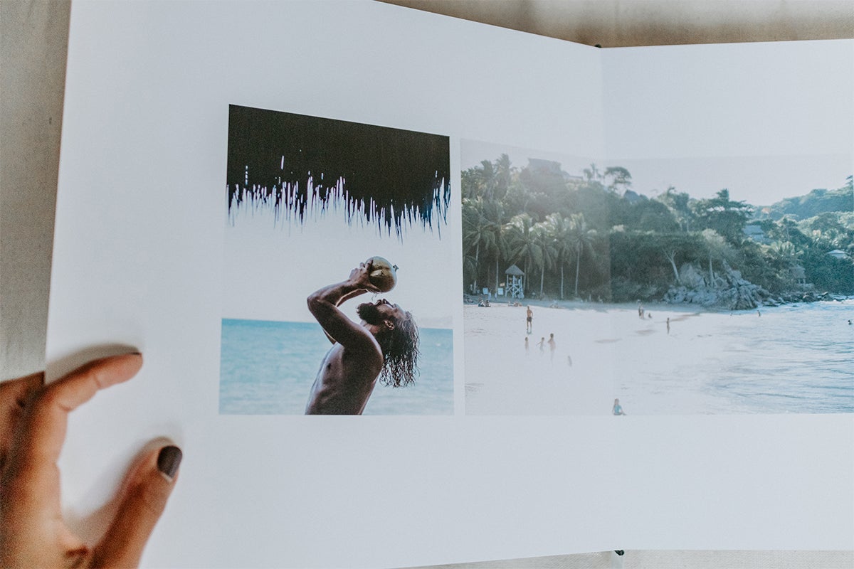 Signature Layflat album opened to image of groom drinking from a coconut