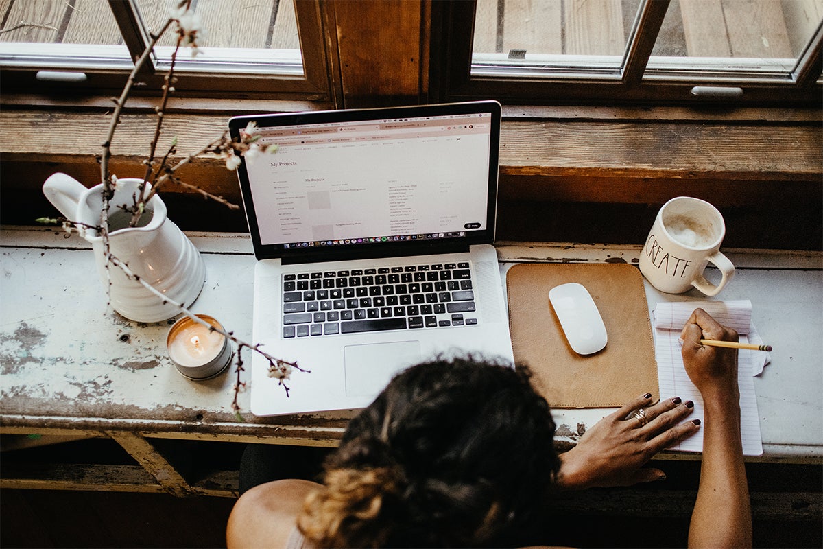 Woman with notepad and laptop