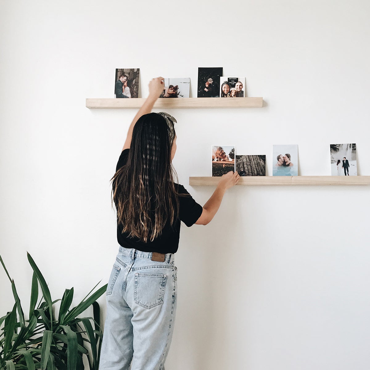 Woman organizing photos on Artifact Uprising Wooden Photo Ledge