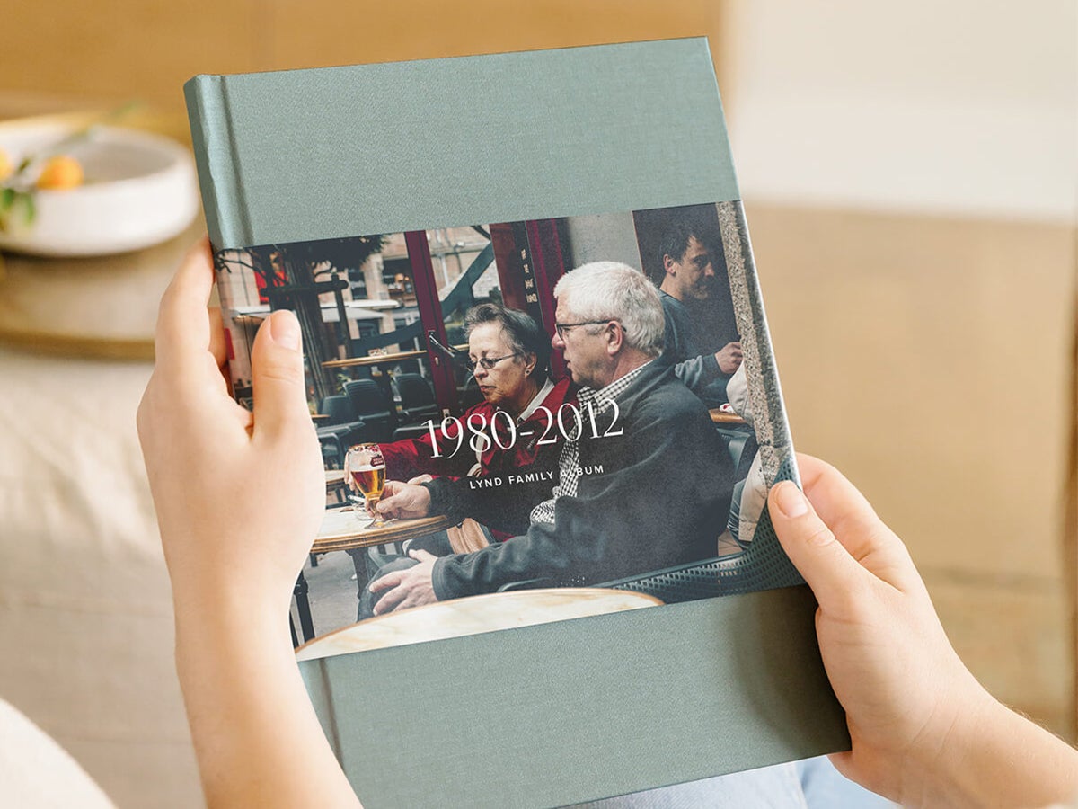 Hands holding up family history album for the Lynd Family