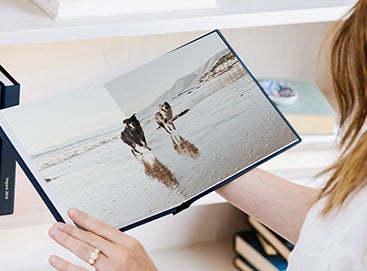 Woman looking at photo book album of her dogs