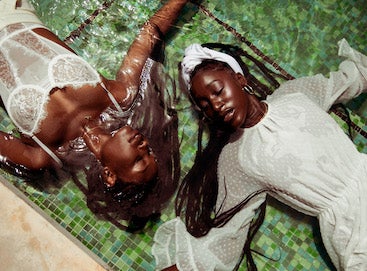 Photo by Andre L. Perry of two Black women laying side by side in water