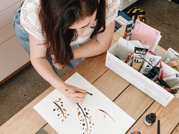 Kate Arends drawing holiday card designs in her studio