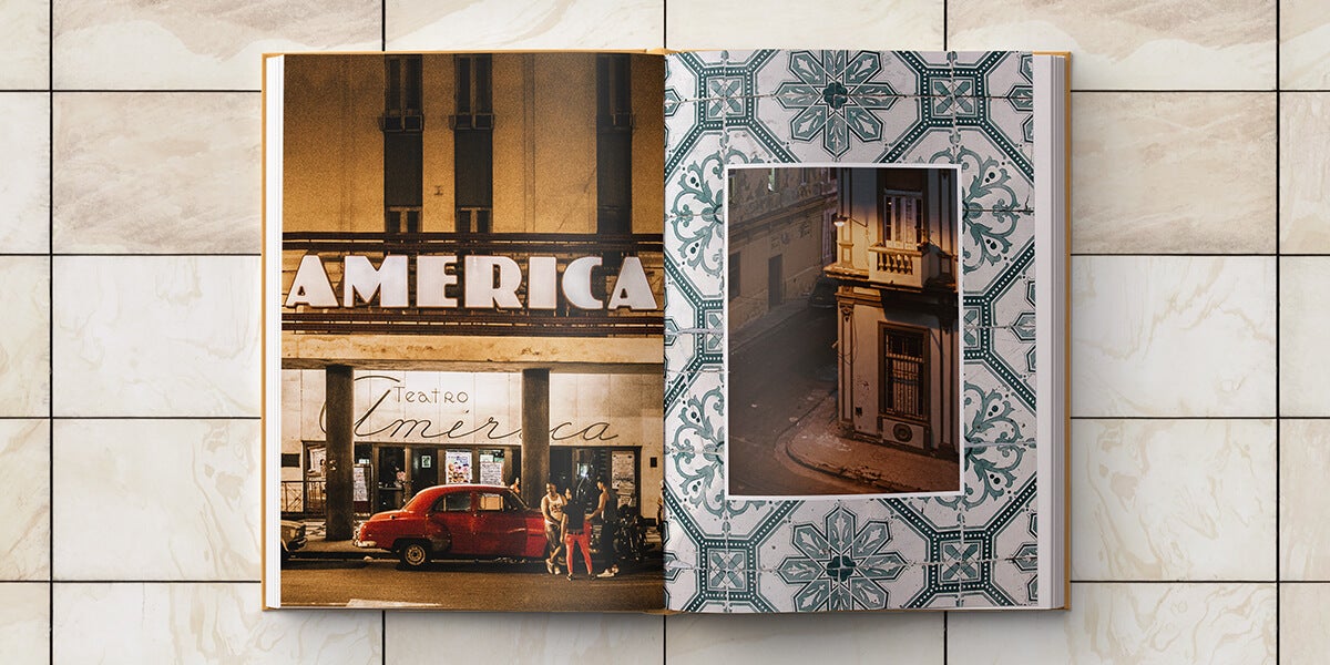 Cuba photo album opened to photo of people next to muscle car parked in front of theater