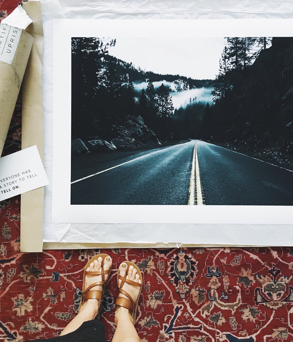 Large Format Print still in packaging unrolled at woman's feet