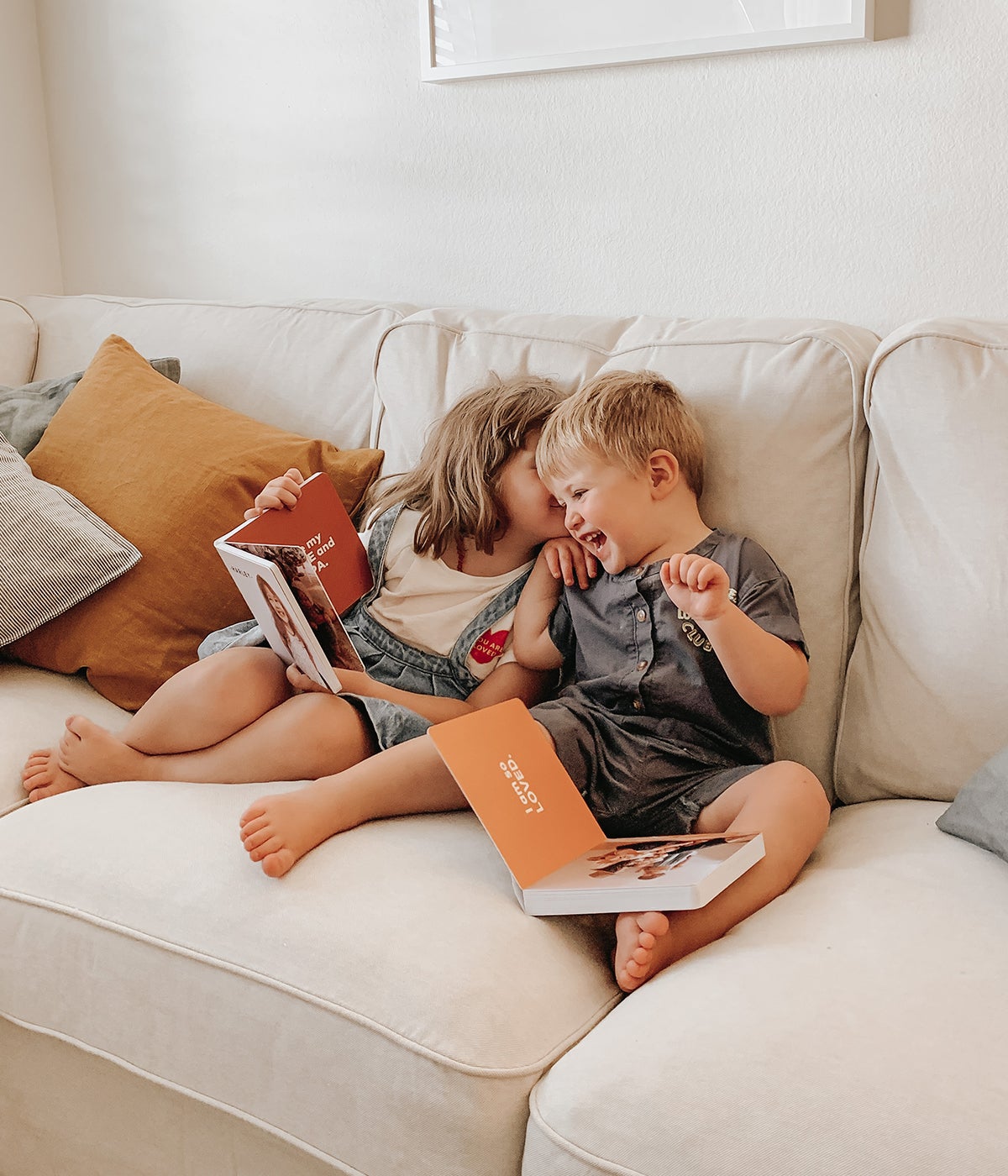 Young siblings laughing as they read board books