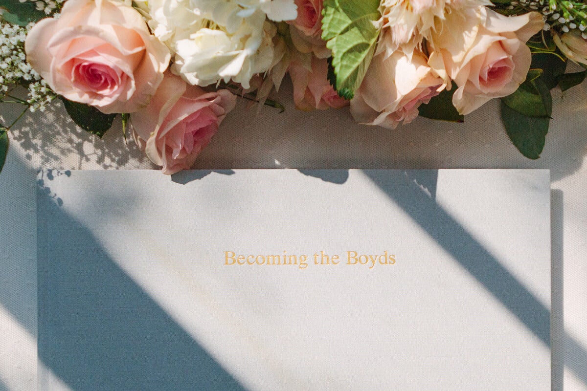 Cover of wedding guest book on table next to flowers